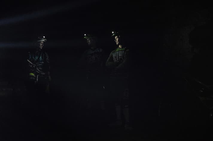   Die Helmlampe als einzige Lichtquelle: Guide Lucas (Mitte) kennt sich in Schwarz der Schächte aus, solange man den Kegel seiner Helmlampe sieht, muss man sich keine Sorgen machen.