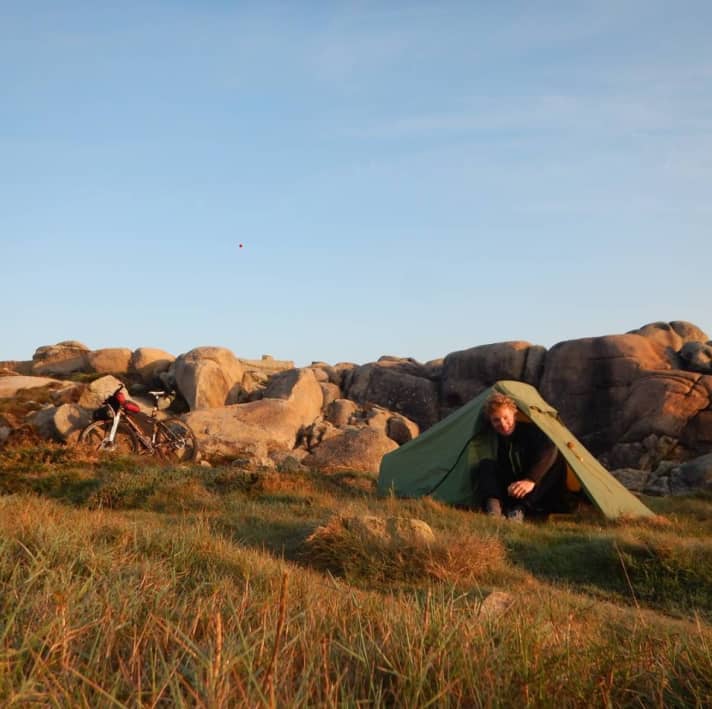 BIKE-redacteur Jan Timmermann kruipt uit de Nordisk Svalbard 1 PU aan de Spaanse Atlantische kust. Op lange bikepacking-tochten bieden tenten het hoogste niveau van comfort.