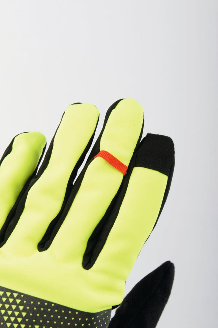 Das hat uns gefallen: Die Signalfarbe des Pearl-Izumi-Handschuhs verbessertdie Sichtbarkeit. Dierote Schlaufe am Mittelfingererleichtert dasAusziehen | 
