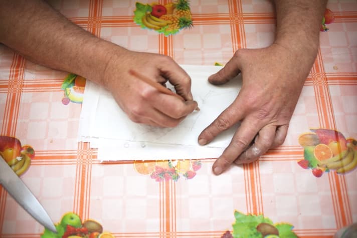   Dario Pegoretti skizziert auf dem Küchentisch einen Rahmen auf der Küchenrolle