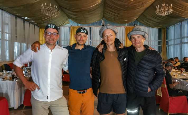   Das Gewinner-Team Janis Viskers und Toms Alsbergs aus Lettland (10d:13h:45m) mit Siegerhüten und die Drittplatzierten Philipp Markgraf und Markus Weinberg (GER) (11d:17h:27m) auf der Finisher-Party im Zielort Balyktschy.