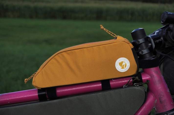 Die Oberrohrtasche sitzt stabil, auch wenn sie “nur” mit Klettbändern befestigt ist. Noch stabiler, wenn im vorderen Bereich eine obere Schlaufe verwendet wird.