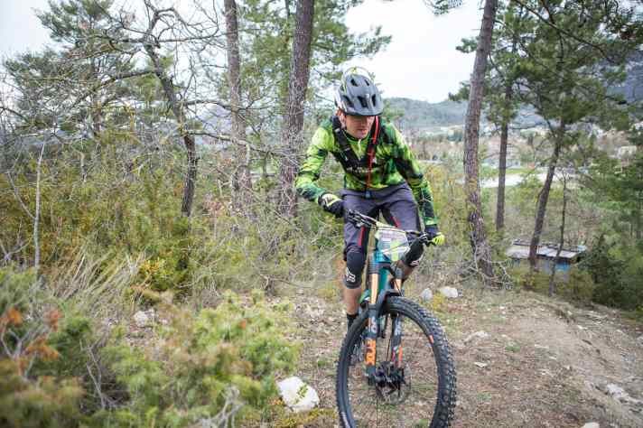   Auch bergauf wird auf technischen Trails geklettert. Oft müssen die Teilnehmer ihr Rad schieben oder tragen, um die Hänge der Seealpen zu erklimmen.
