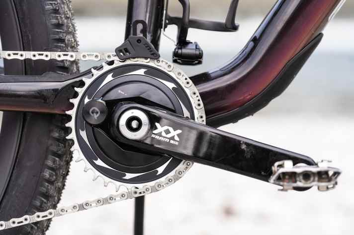 Die Werte des Powermeters werden via Funk ans Rockshox Flight Attendant Fahrwerk des Specialized S-Works Epic gesendet und bieten die Grundlage für dessen Entscheidungsfindung. Eine Kettenführung hält den Antriebsstrang an Ort und Stelle.