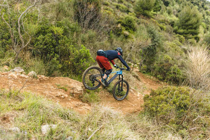 Der Impuls wird auf den Lenker übertragen, das Vorderrad wird entlastet. Wichtig ist, dass dieser Impuls über beide Arme gleichzeitig und gleichmäßig ausgeübt wird, damit Bike und Pilot in der Luft nicht in Schräglage kommen. Auch hier hilft es übrigens, den Blick möglichst weit nach vorne auf den angepeilten Landepunkt zu richten.