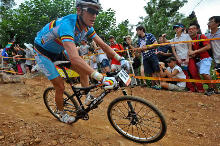   Roel Paulissen aus Belgien auf der Olympia-Strecke 2008 in Peking. Dies war der erste MTB-Kurs, der zu größten Teilen künstlich angelegt wurde. Die technischen Elemente waren spektakulär, aber dennoch überschaubar. <a href="https://www.bike-magazin.de/tag/julien-absalon" target="_blank" rel="noopener noreferrer nofollow">Julien Absalon</a>  holte sich nach Athen hier zum zweiten Mal die Gold-Medaille und machte sich damit unsterblich. <a href="https://www.bike-magazin.de/mtb_news/szene_news/start-ziel-sieg--sabine-spitz-holt-gold" target="_blank" rel="noopener noreferrer nofollow">Sabine Spitz holte die Gold-Medaille bei den Damen</a> .
