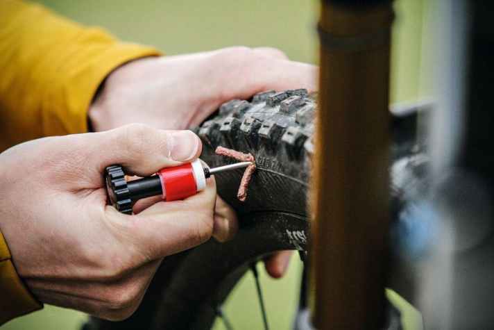 Loch lokalisieren, “Würstchen” in die Öffnung drücken und das Tool langsam herausziehen. So wendet man die Reparatur-Set für Tubeless-Reifen an.
