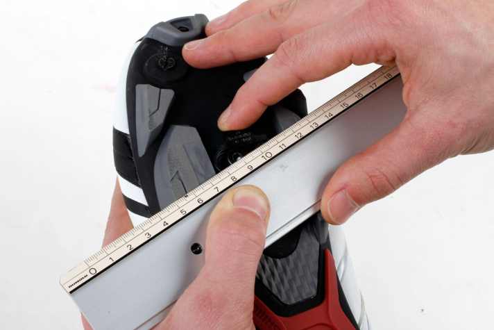   Zieh den Schuh wieder aus und schraub das Cleat locker an die Sohle, sodass es sich noch leicht bewegen lässt. Mit einem Lineal verbindest Du nun die beiden Punkte. Die Mitte des Cleats sollte nun genau unter dem Lineal liegen.