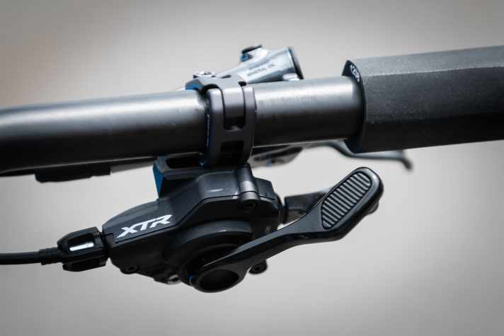   I-SPEC war gestern! Bei der neuen Shimano XTR kommt die Weiterentwicklung I-SPEC EV zum Einsatz. Die Lösung, mit der man Schalt- und Bremshebel an einer Schelle montieren kann, wurde optimiert. Nun kann man den Hebel um 14 mm seitlich verschieben und um 60 Grad rotieren.