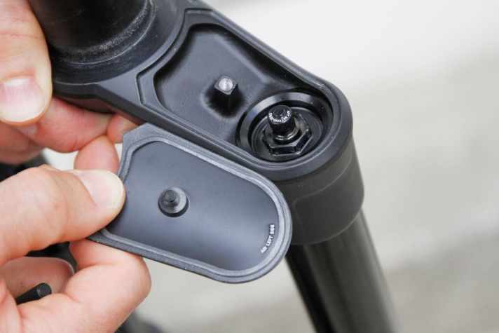   Beide Seiten der Gabelkrone besitzen einen abschraubbaren Deckel. Links ist das Ventil für die Luftfeder, rechts sitzt die Dämpfungseinstellung.