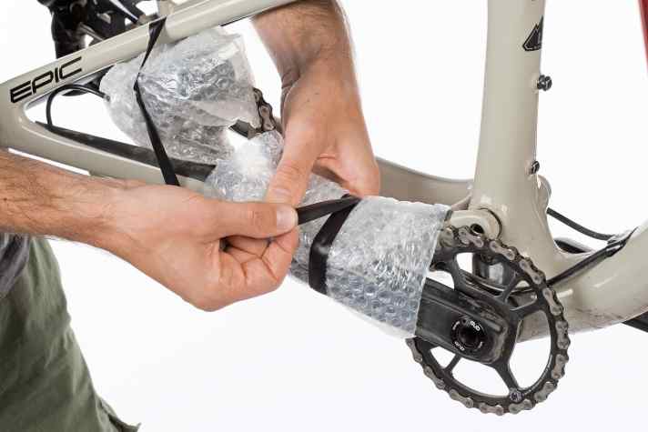   Tipp vier: Sichern Sie die Kurbel waagerecht an der Kettenstrebe mit einem Kabelbinder oder etwas Panzertape. Wickeln Sie zusätzlich die Kette noch in Luftpolsterfolie, dann bleibt die Tasche länger frei von Schmierflecken. 