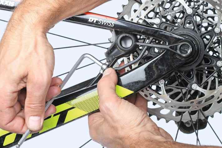   4 Quietschende Bremsen neu ausrichten: Sattelschrauben lösen, Bremshebel ziehen, Schrauben abwechselnd nachziehen – so richtet sich der Brems­-sattel neu aus.  