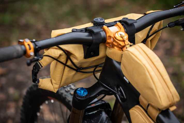 Eingehängt und zugedreht: Komfortabler als mit einem Boa-Verschluss lässt sich womöglich keine Tasche am Bike befestigen. Die Klemmkraft reicht allerdings nicht aus, die beladene Lenkertasche will sich auspendeln und kann sich verdrehen. Ohne Abstandshalter, die sich beispielsweise am Steuerrohr abstützen, drückt die Tasche dann gegen die Leitungen.