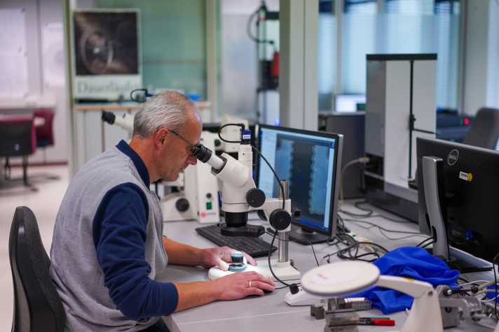   Die Zuverlässigkeit der Teile ist ein wichtiger Part bei der Entwicklung, denn zu viele Garantiefälle oder gar Rückrufe können zum wirtschaftlichen Desaster werden. Im Messlabor werden alle Prototypen vor und nach dem Testen mit einem 3D-Scanner zu digitalen Modellen umgewandelt. Fünf Millionen Messpunkte werden dabei erfasst. In dem Raum herrschen konstant 20 Grad, um Abweichungen aufgrund temperaturabhängiger Materialausdehnung auszuschließen. Die Messungen, die unter anderem von Ingenieur Thomas Fella (Foto) vorgenommen werden, offenbaren jeden Hauch von Verschleiß.
