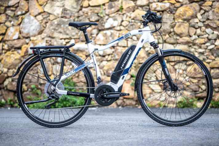 Trekking E-Bikes sind mit Schutzblechen, Lichtanlage und Gepäckträger ausgestattet.