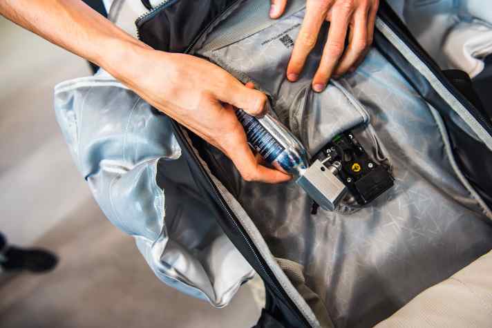 Die Kartusche wird in den Rucksack eingesetzt. Der Zündmechanismus sitzt im ebenfalls wiederverwendbaren Alu-Block am Kopf der Kartusche.
