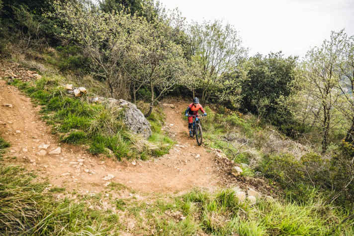   Grundsätzlich bleibt man beim ganzen Manöver im Sattel sitzen, um konstanten Druck auf dem Hinterrad zu halten. Die <a href="https://www.bike-magazin.de/emtb/service_wissen/how-to-emtb-uphill-fahrtechnik-2022-video-02-grundtechnik" target="_blank" rel="noopener noreferrer nofollow">Unterstützungsstufe</a>  ist Geschmackssache: Geringere Stufen lassen sich besser dosieren, brauchen aber mehr Beinkraft. Vor der Kurve schaltet man runter auf einen relativ leichten Gang.