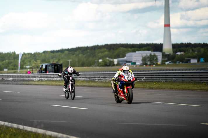 272 km/h: Das Superbike vorne schleppt Elias Schwärzler zum Weltrekord als "schnellster Mensch, der auf einem Fahrrad gezogen wurde".