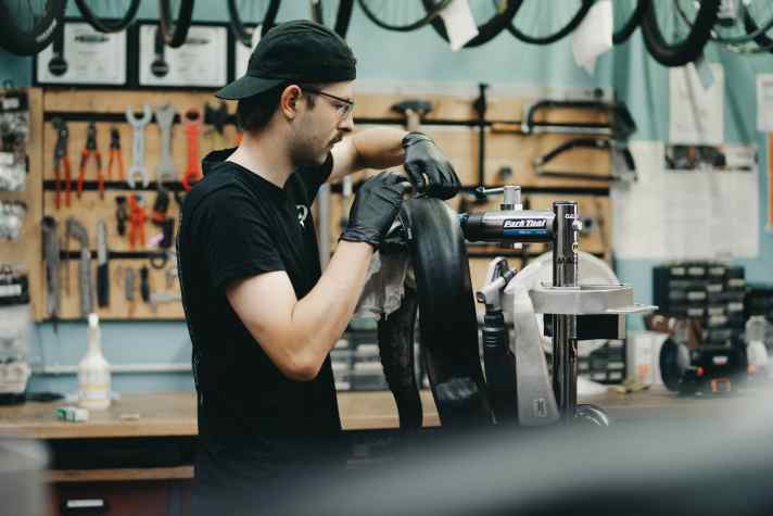 Paul vom TriShop Saar flickt den Reifen mit einem Stück Schlauch. Danach wird er wieder tubeless montiert – und hält bis zum Ende.