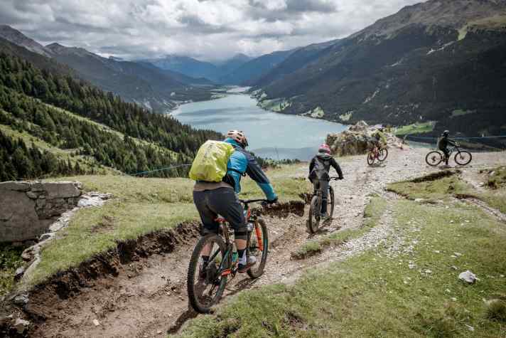 Super Trails und beste Aussicht: Auf der Hochebene Plamort gibt es freien Blick auf den Reschensee und das von Wolkenbergen umwaberte Ortler-Massiv.