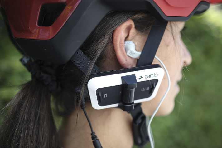 In-Ear-Kopfhörer, wie hier am Cardo Packtalk Outdoor, sind im Straßenverkehr nicht erlaubt. Dank Mesh-Kommunikation sind Biker unabhängig vom Mobilfunknetz.