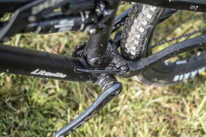 Linksseitig über dem Tretlager des Liteville Bikes laufen die Leitungen für Bremse und Schaltung kurz extern. Letztere muss jedoch kurz nach der Klemmung wieder die Seite wechseln.
