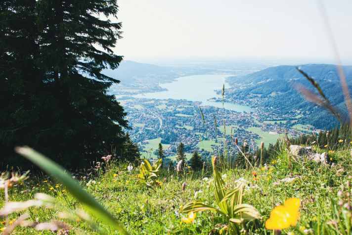 Der Tegernsee liegt im Landkreis Miesbach und ist auch für Münchner ein beliebtes Ausflugsziel. Radfahren auf Wegen unter 1,50 Meter Breite soll in den umliegenden Landschaftsschutzgebieten nun verboten werden.