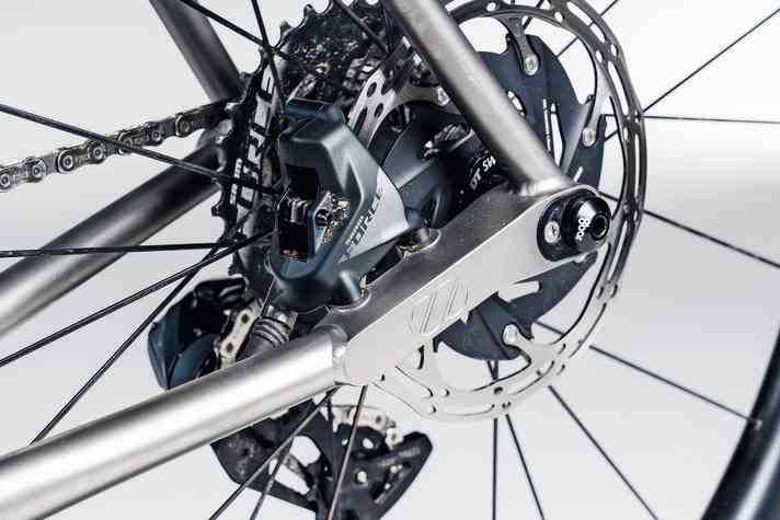 Anpassungsfähig: Ein eingeschweißtes Frästeil nimmt am 8bar Mitte TI Bremssattel und Steckachse auf. Mit dem ovalen Insert lässt sich der Radstand verkürzen.
