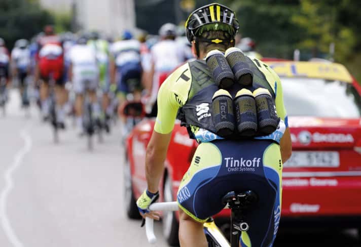 Trinken ist essenziell, beim Radfahren im Sommer wie im Rennsport. Der Fahrer im Bild holt sieben Flaschen für sein Team, jedes Mitglied trinkt am Tag rund sechs Liter.