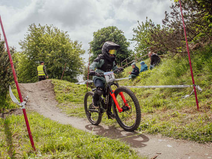   Auf dem Pumptrack-ähnlichen Kurs kamen die Kids mit ihren Mini-Downhillern ordentlich aus der Puste. Fullface-Helm und Protektoren waren natürlich Pflicht. Das hielt allerdings keinen davon ab, auf der anfangs etwas tretlastigen Strecke mit Vollgas aus dem Starthäuschen zu sprinten.