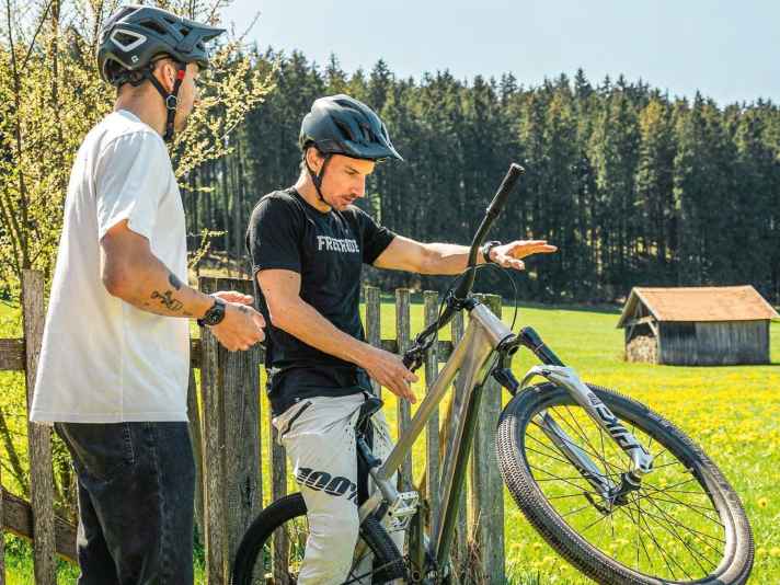 Übung Nr. 1: Coach Korbi zeigt, wie man ein Gefühl für die Lenkerdrehung bekommt. Das Hinterrad lehnt dafür am Zaun, der Lenker kann kreiseln.