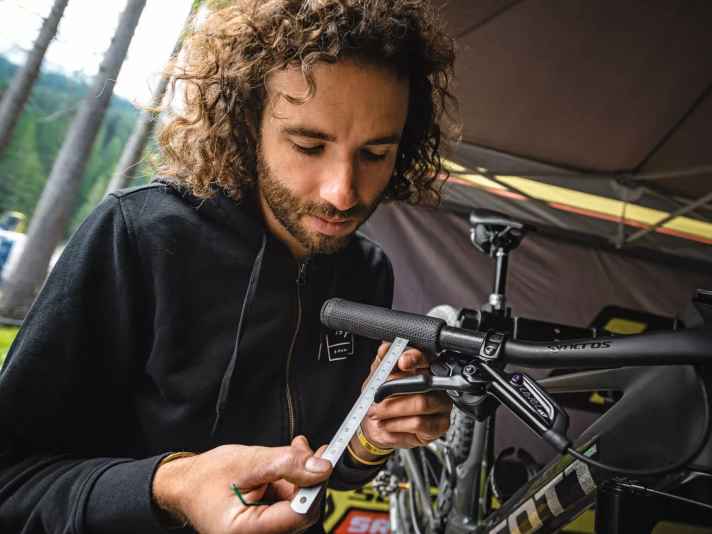 Yanick kontrolliert die optimale Griffweite an Nino Schurters Racebike. 