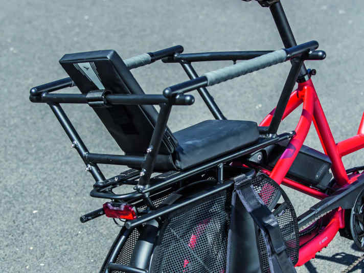 Kindersitz mit Käfig: Das Geländer sowie textile Fußrasten und ein Speichen-Schutzgitter gewährleisten einen sicheren Transport.
