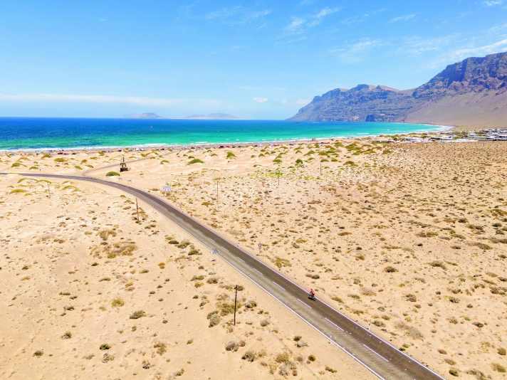 Radreise Lanzarote: Der lange Sandstrand bei Caleta de Famara ist wegen des fast ständig wehenden Windes bei Surfern sehr beliebt.