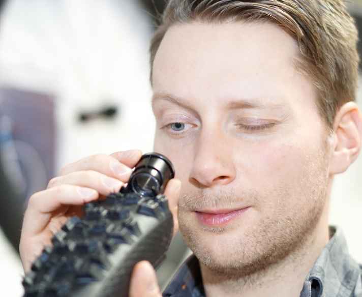   Sebastian Moos ist einer von drei Produkt-Managern von Continental’s Fahrrad-Sparte. Er ist für die Mountainbike-Modelle zuständig. Knapp ein Jahr lang dauert die Entwicklung eines neuen Profils. Die große Kunst ist es, den optimalen Kompromiss aus Grip, Rolleigenschaft und Laufleistung zu finden. Jede MTB-Spielart hat ja da ihre eigenen, speziellen Anforderungen. Der Aufbau eines Reifens ist im Groben bei jedem Modell gleich: Ganz unten eine von ultradünnen, stabilen Nylonfäden durchsetze Gummimatte – die Karkasse. Darauf die deutlich dickere Lauffläche. Und seitlich die Aramidfäden, damit der Reifen stabil auf der Felge sitzt.