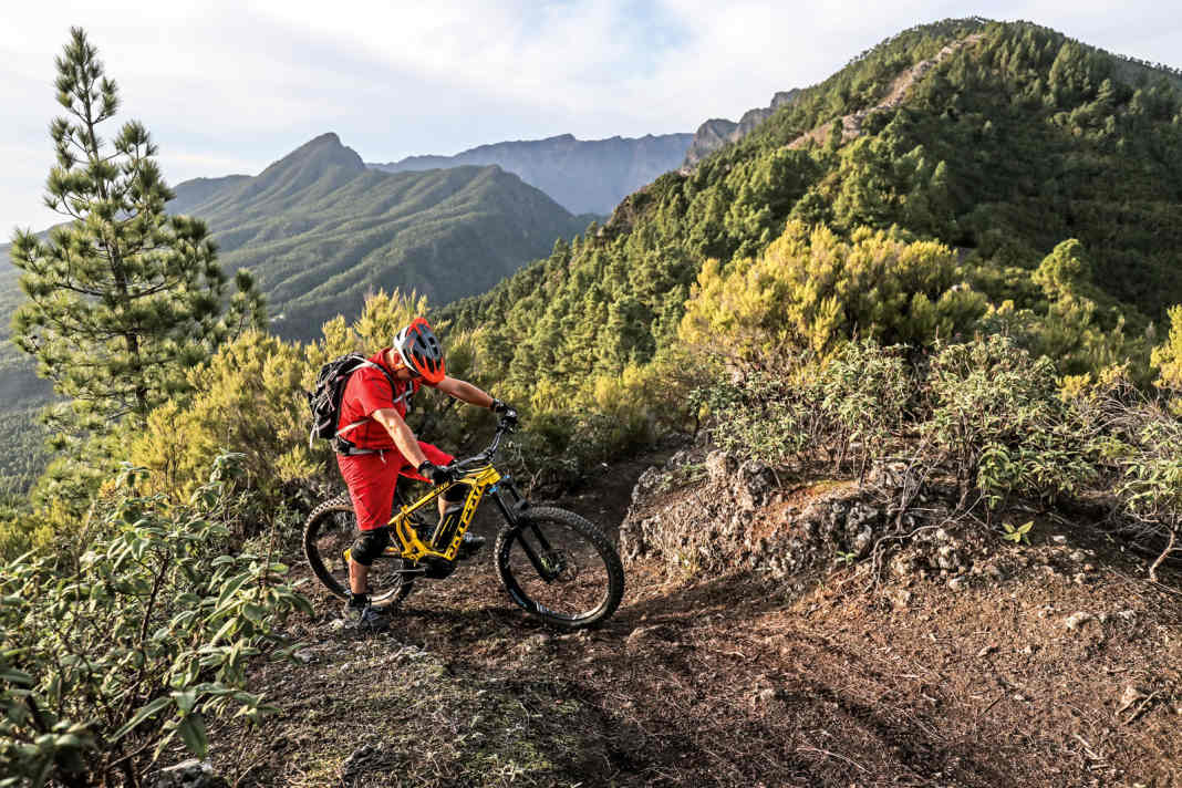 Das Allerwichtigste: Fahren Sie erst los, wenn beide Füße auf den Pedalen stehen. Das wird immer wieder falsch gemacht. Diese Technik gilt übrigens nicht nur fürs Anfahren am Berg, sondern auch fürs Wiederaufsteigen im Downhill! Bild 1: Um am Berg anzufahren, stellen Sie das Bike zunächst leicht quer zum Hang. Der "Talfuß" steht auf dem Pedal, der "Bergfuß" auf dem Boden. Die Talkurbel sollte im 45-Grad-Winkel nach oben stehen. Wählen Sie die Unterstützungsstufe nicht zu hoch, bei Bosch-Motoren passt "Tour" meist ganz gut. Die Bremsen sind gezogen. Der Gang ist abhängig von der Traktion in den seltensten Fällen der kleinste.