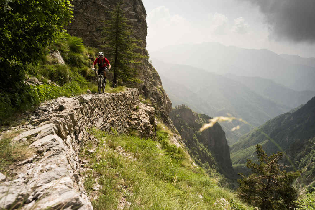 Tatsächlich scheint der Pfad die vertikale Felswand zu durchqueren. Er zieht sich wie eine überdimensionale Narbe über den Stein.