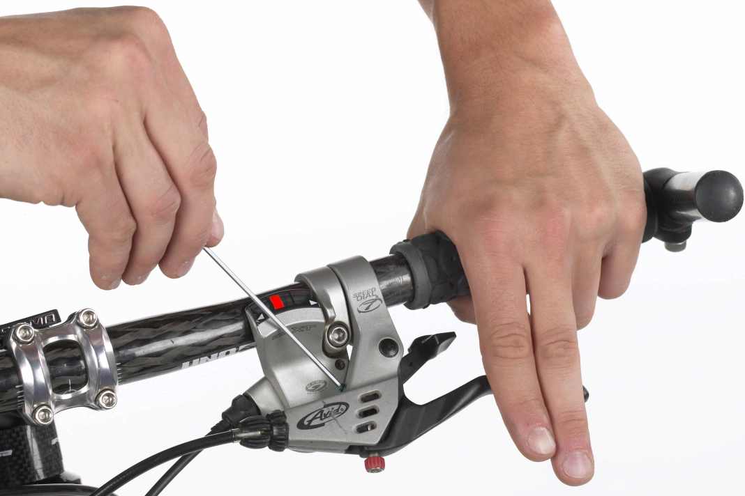 1. HEBELPOSITION UND GRIFFWEITE Wer ergonomisch greift, spart viel Kraft. Gerade auf langen Abfahrten ermüden die Hände langsamer, wenn die Griffweite stimmt. Fast alle V-Bremsen haben dafür eine Stellschraube. Mit einem Inbus-Schlüssel (Größe 2/2,5 oder 3) die Schraube so weit verdrehen, dass der Hebel kurz vor dem mittleren Fingergelenk steht.