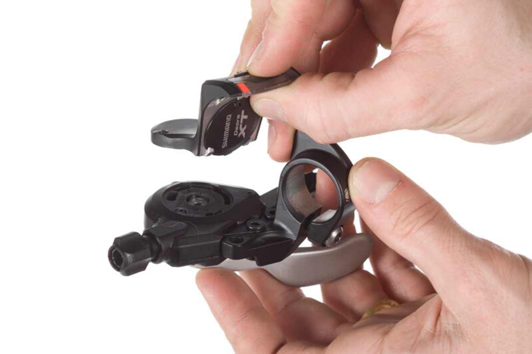 Anzeige abbauen
Eine gemeinsame Schelle für Schalthebel und Bremse à la SRAM gibt es bei Shimano derzeit nicht. Wenn man jedoch die Ganganzeige vom Shifter abmontiert, kann man den Hebel auf beide Seiten des Bremsgriffs montieren. Mit Anzeige passt der Shifter nur innerhalb des Bremsgriffes an den Lenker.