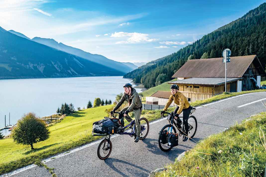 Grüne Wiesen, blauer Himmel, klares Wasser: Der Weg am Reschensee entlang kommt einem Naturschauspiel gleich. In Südtirol warten nicht nur tolle Radwege, sondern auch jede Menge kulinarischer Freuden.