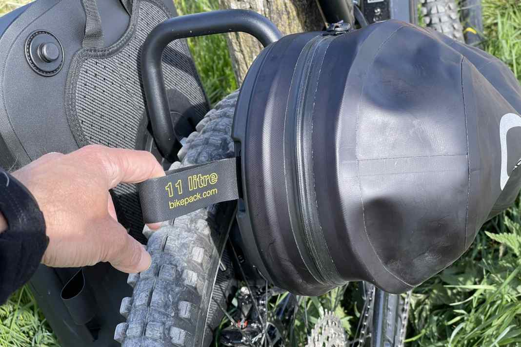 An diesem Riemen entriegelt man das Quicklock-System und kann den Packsack entweder abnehmen oder drehen und anders positionieren.