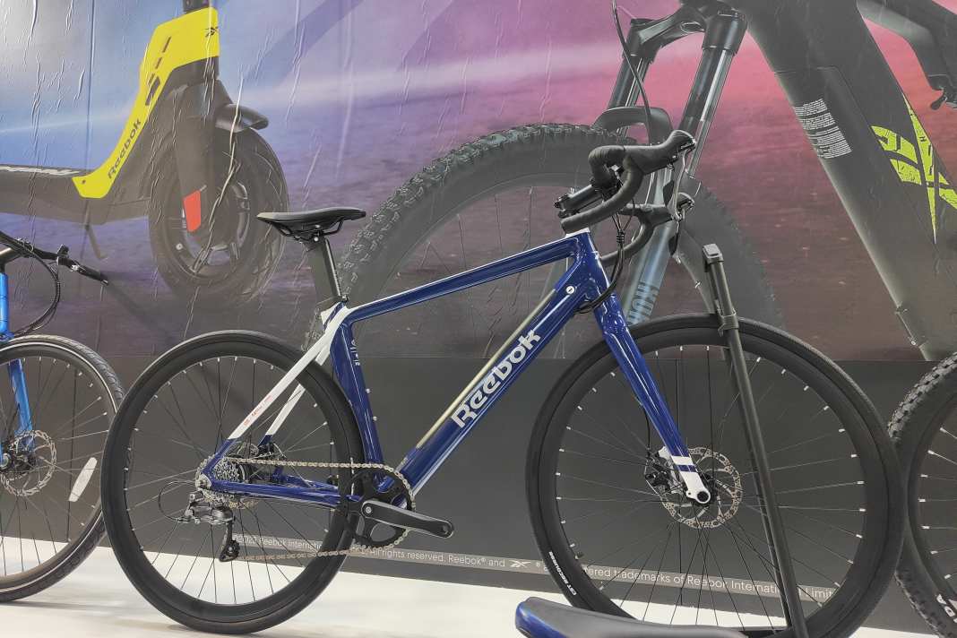Etwas unscheinbar stellt der ehemalige Sport-Riese Reebok seine ersten E-Bikes auf der ISPO vor. Ja, Reebok hat jetzt eine Auswahl von E-MTBs, E-Gravelbikes, E-Commuter...