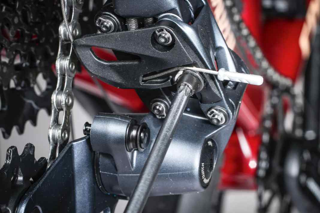 1 Schaltzug lösen: Schalten Sie aufs kleinste Ritzel der Kassette und lockern Sie die Befestigungsschraube des Schaltzugs. Bevor Sie den Stahlzug entfernen, prägen Sie sich nochmals ein, wie er am Schaltwerk befestigt ist.
