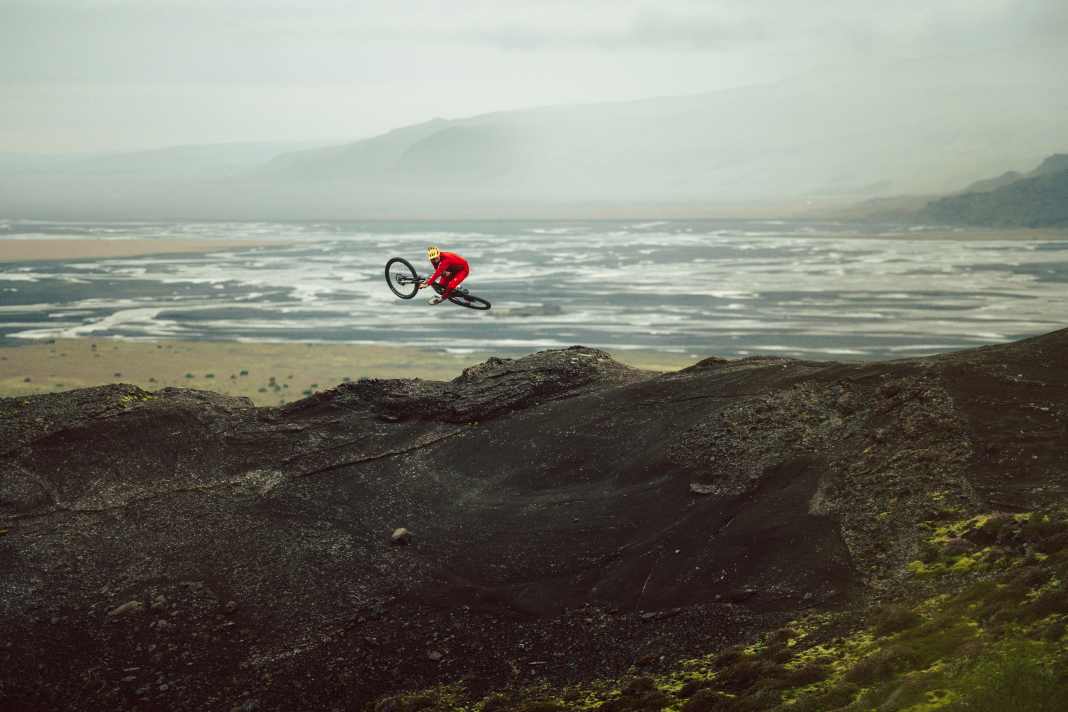 Mountainbiken auf Island: „Hier wirst du jeden Tag nass“, sagt Korbi Engstler. Hier legt der Style-Master sein Ghost-Enduro flach während im Hintergrund die Wellen rollen.