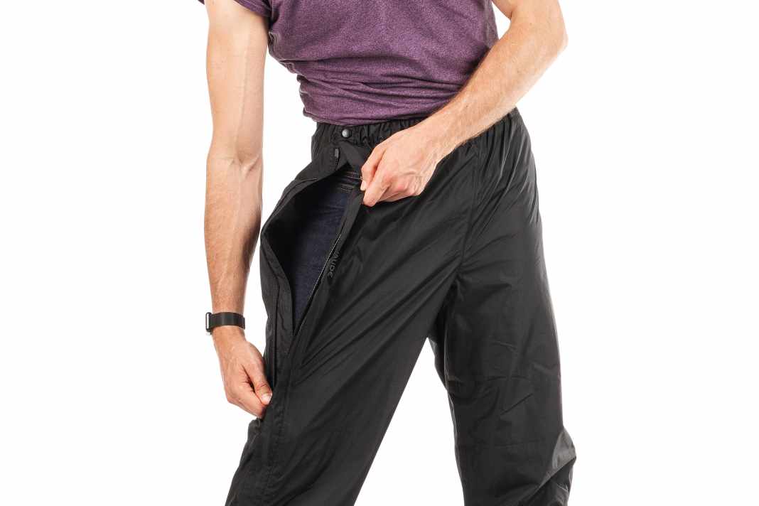Vaude Fluid Full-Zip, 450 Gramm
Besonderheiten: teilbarer Reißverschluss, verstellbare Beinweite, Netzfutter, Reflexprint
Fazit: Vaudes eher voluminös zu verpackende Hose überzeugt mit einem durchgehenden Reißverschluss, der das Anziehen erleichtert. Sie ist weit und wenig radspezifisch geschnitten, aber am Unterschenkel per Klett anzupassen. Vielleicht zu viel Hose für den Stadtverkehr, aber sicher ein Tipp für Radurlauber in nassen Gegenden.