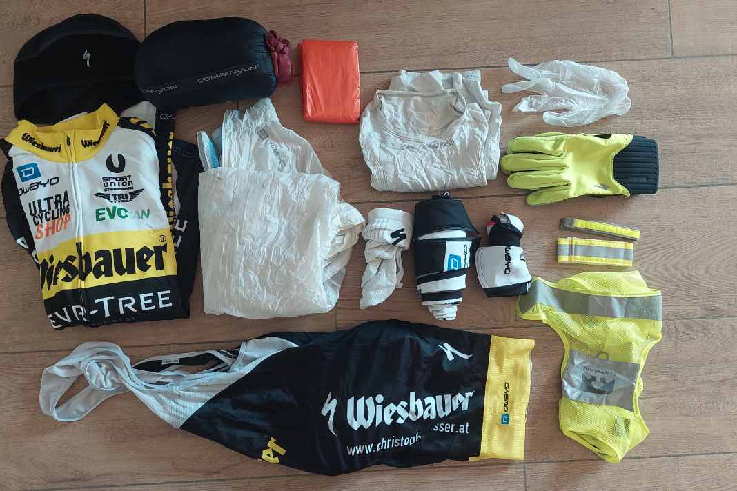 Kleidung & Schlaf-Equipment: Thermomütze, Thermo-Trikot, Regenjacke, Baselayer, Socken, Bib Short, Beinlinge, Armlinge, Winterhandschuhe, Latex-Handschuhe als Regenschutz, reflektierende Weste und Straps, Notfallbivi und Schlafsack