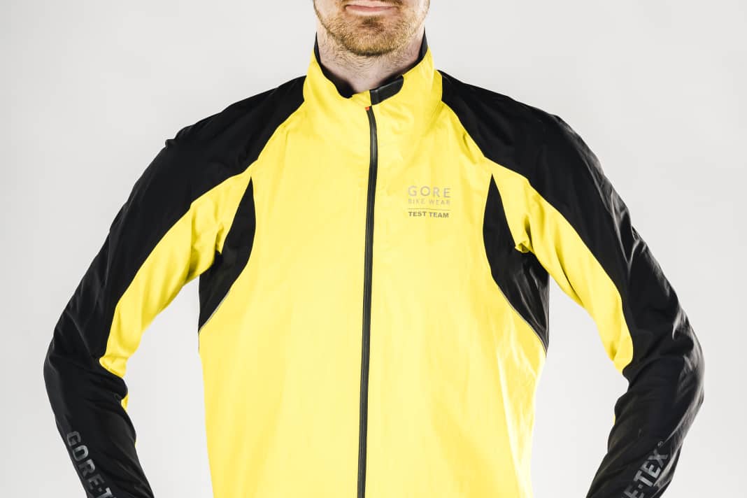 Der Schnitt der Regenjacke muss die gebeugte Haltung auf dem Rennrad vorwegnehmen und darf auch mal eine Nummer größer ausfallen, damit noch ein wärmendes Trikot darunter passt
