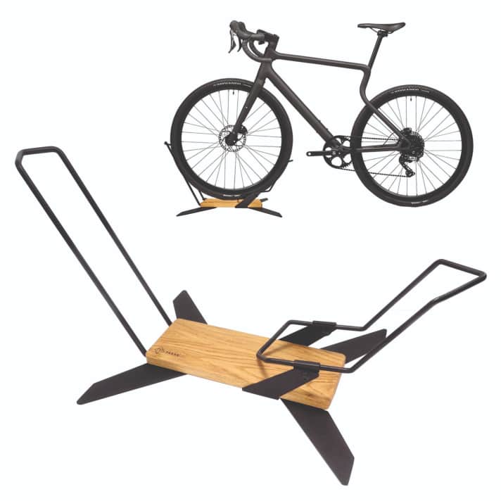 Showroom-Atmosphäre versprüht dieser Bikehalter namens „X-Stad“ von Parax für unter 100 Euro >> <a href="https://www.awin1.com/cread.php?awinmid=14353&awinaffid=471469&clickref=B+X-Stad+Parax&ued=https%3A%2F%2Fwww.decathlon.de%2Fp%2Fmp%2Fparax%2Fx-stand-fahrradstaender%2F_%2FR-p-a8edbe1f-8ebf-45aa-b89b-86b2ac51a8b0" target="_blank" rel="noopener noreferrer nofollow">hier erhältlich</a>*. Durch das Holz wirkt er eher wie ein Möbelstück, der „geknickte“ Teil der für fast alle Radgrößen passenden Bügel ist kippbar, man kann das Bike also quasi in ihn hineinfahren und muss es nicht mal anheben!