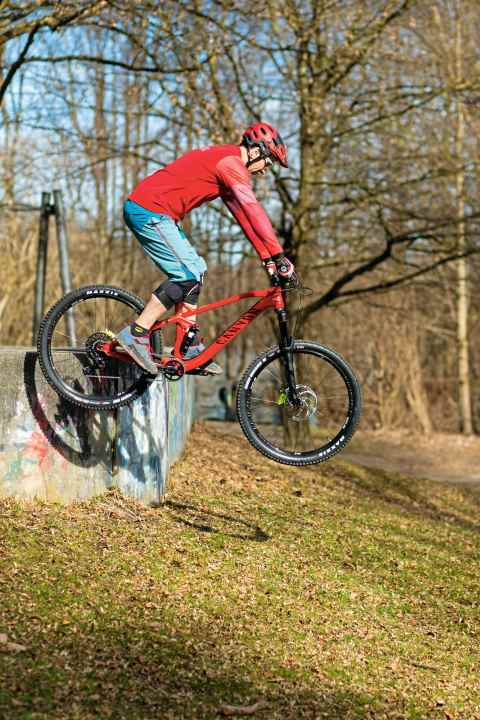   Airtime: Was jetzt folgt, ist der freie Fall. War Dein Streckimpuls ausgewogen, segelst Du mit beiden Rädern nahezu auf einer Höhe. Wichtig: eine zentrale Position auf dem Bike. Der Blick visiert bereits die Landung an. Tipp: Die Beine und Arme gehen wieder leicht in die Beugung. Das verhindert, dass Du in der Luft versteifst. | Falsch: Versteifen. Folge: Schräglage