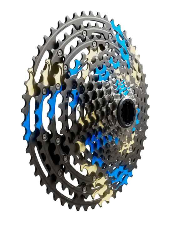 Nein, das ist keine abgefahrene Farbvariante der neuen Shimano XTR Kassette. Die markierten Flächen zeigen die speziellen Gleitbereiche über welche die Kette besonders geschmeidig auf das größere, beziehungsweise kleinere, Ritzel wechseln soll.